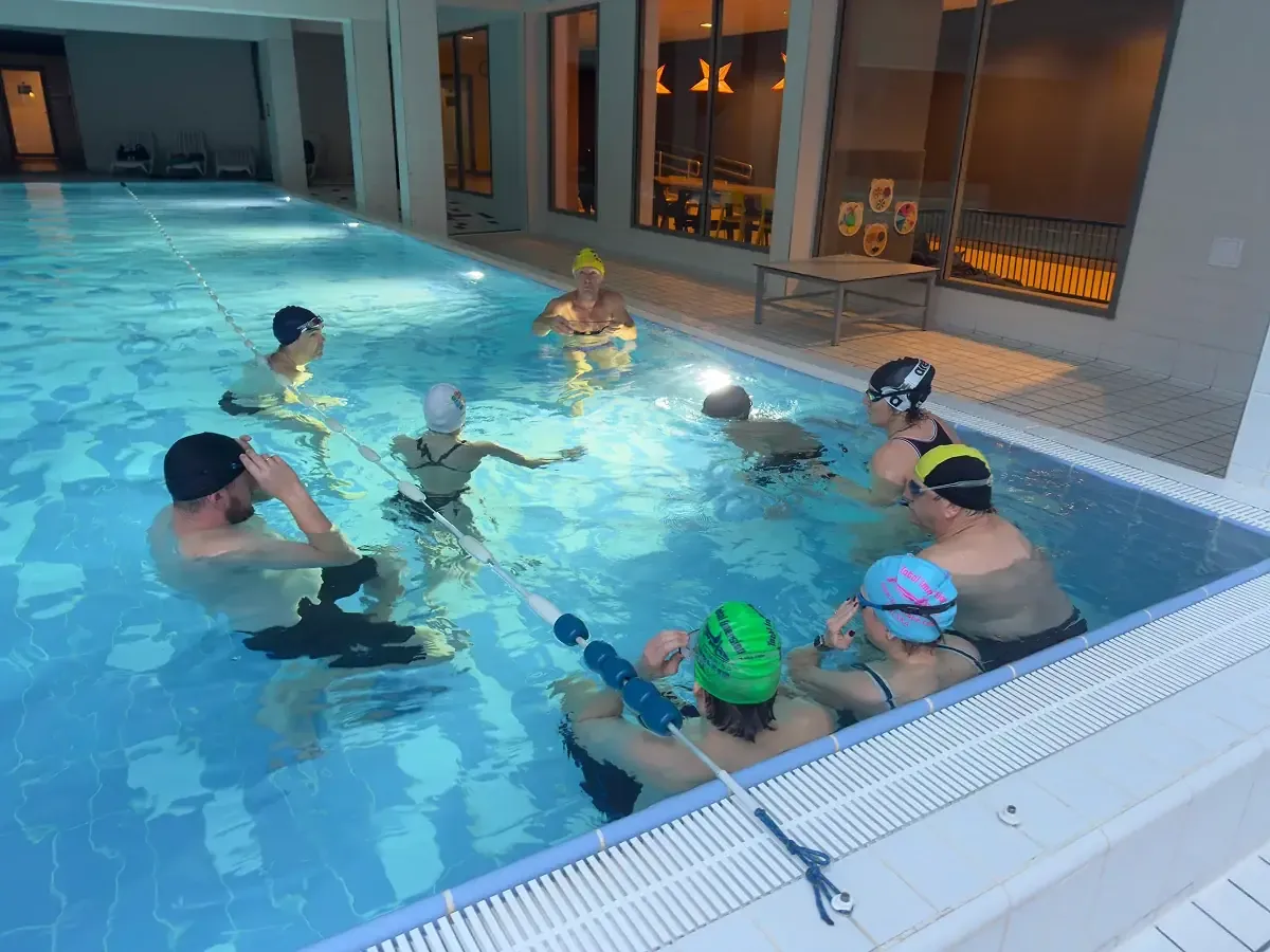 A coach running a group session in the pool, everyone on the same rhythm