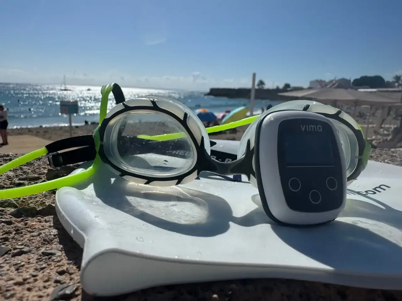 A Vimo, goggles and a kickboard drying on the beach between sets