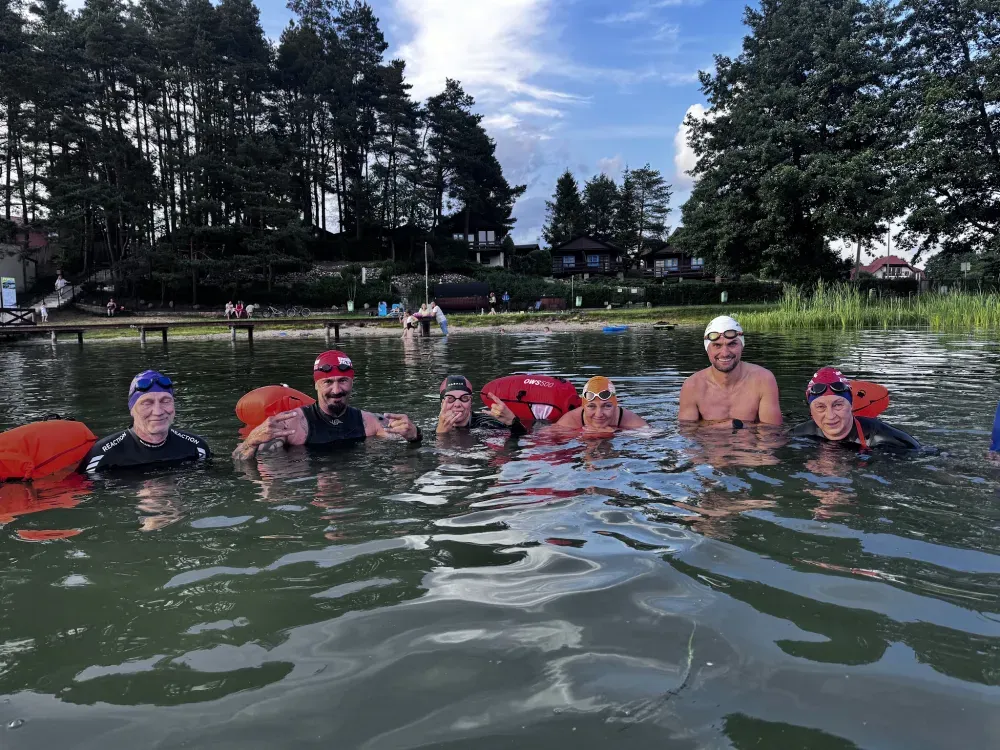 A line of swimmers in the water at golden hour