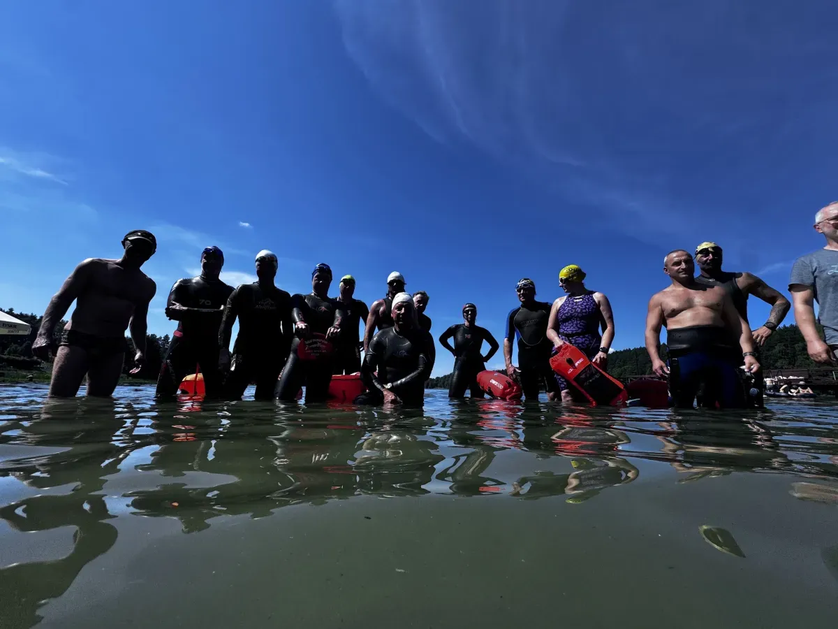 The group standing together in the lake against a bright blue sky