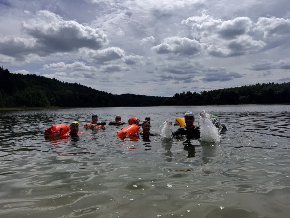 The group together in the lake under a cloudy sky