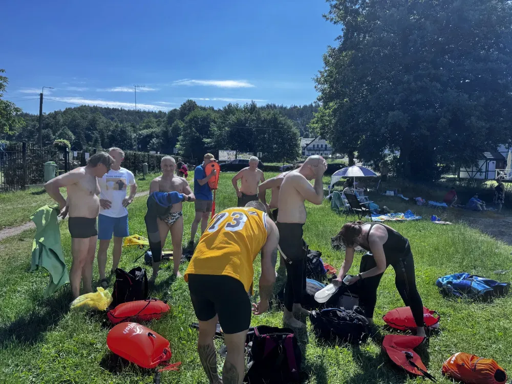 Participants packing up their gear on the grass after a swim