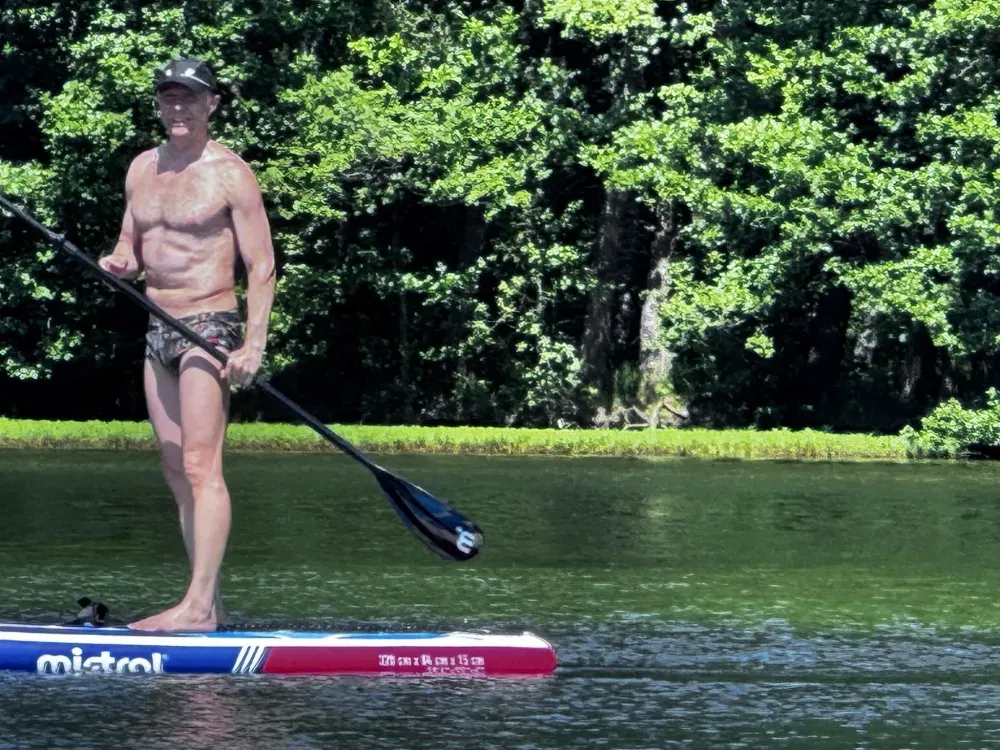 A participant paddleboarding between swims