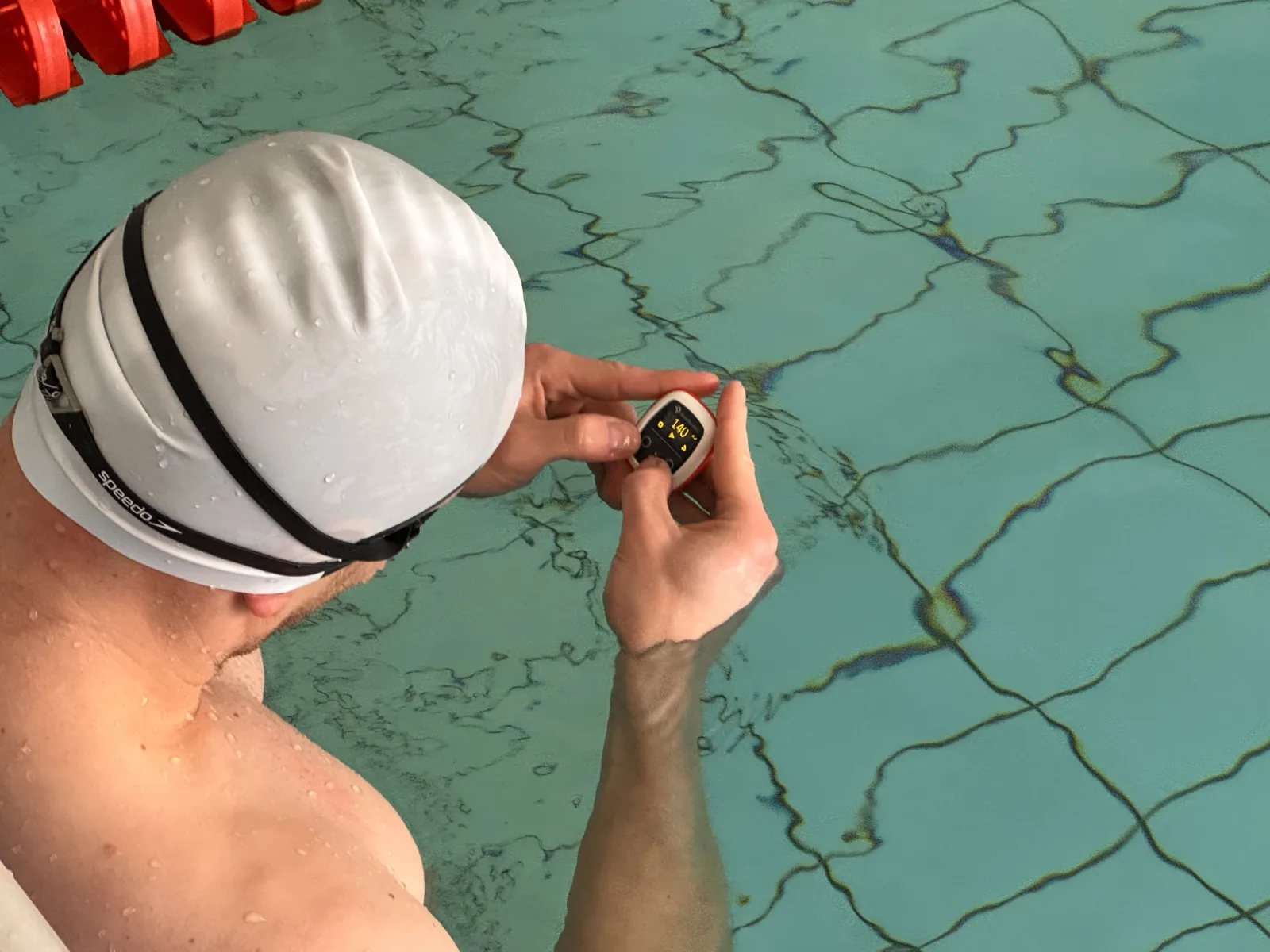 Swimmer setting the tempo on a Vimo Swim device at the poolside