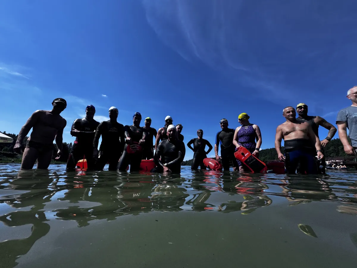 The group standing together in the lake against a bright blue sky
