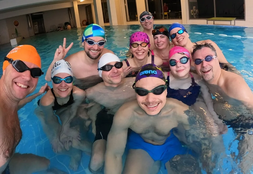 Swimmers training with a tempo trainer in a pool