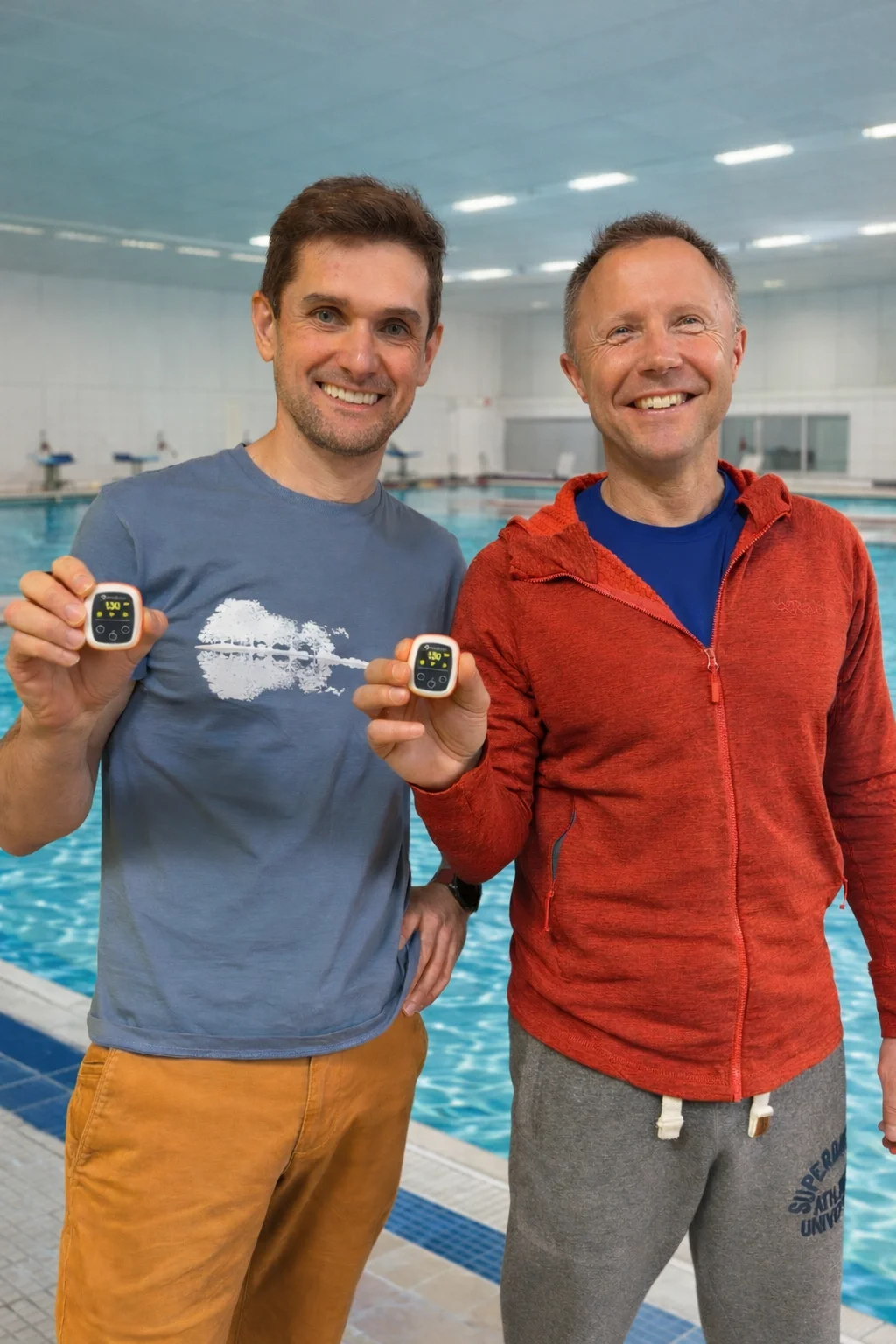 Two Vimo Swim team members holding devices at the poolside